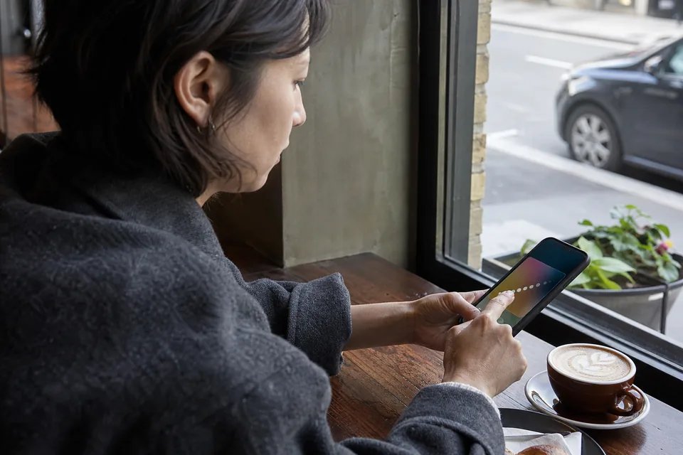 Customer at a cafe window seat answering a short rating question on her phone