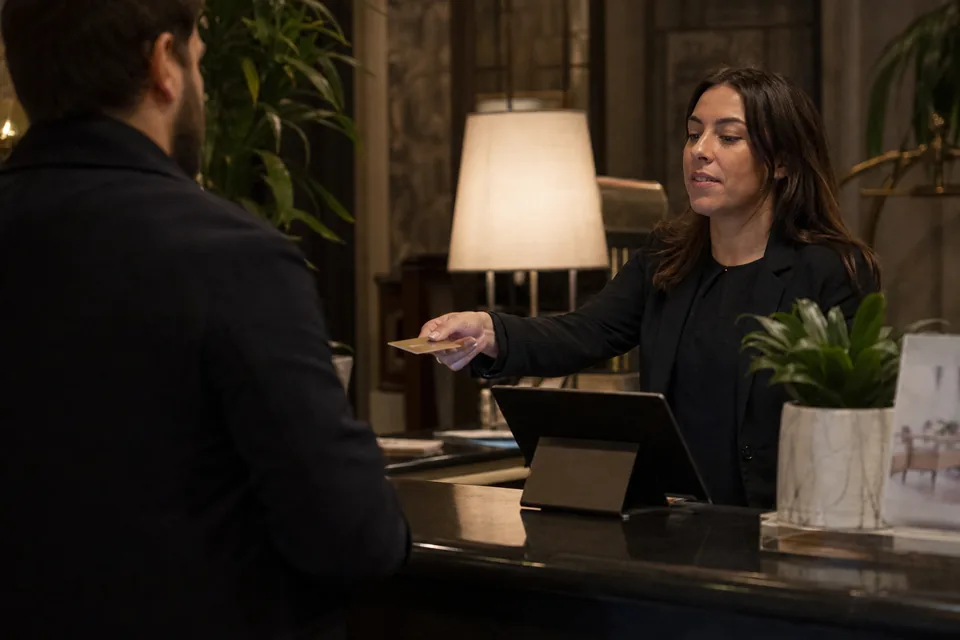 Hotel receptionist at the front desk right after a guest check-out moment